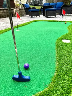 a golf course with a purple ball on a putting green at Beach bliss awaits! - Beach, Pools, Tiki-Deck, Arcade, Putting green, Family Fun! in Panama City Beach