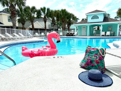 a pink flamingo float next to a swimming pool at Beach bliss awaits! - Beach, Pools, Tiki-Deck, Arcade, Putting green, Family Fun! in Panama City Beach