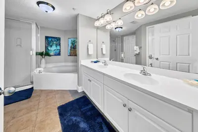 a white bathroom with a tub and a sink at Majestic Beach Towers I 2002 Stay Salty in Panama City Beach