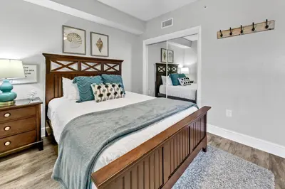 a bedroom with a large bed and a mirror at Majestic Beach Towers I 2002 Stay Salty in Panama City Beach
