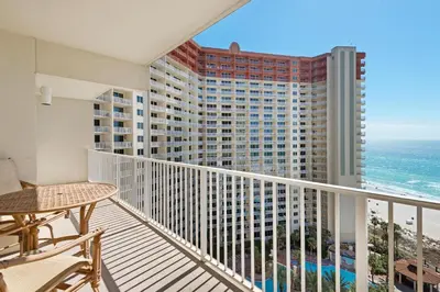 a balcony with a table and chairs and the ocean at Shores of Panama 1313 in Panama City Beach