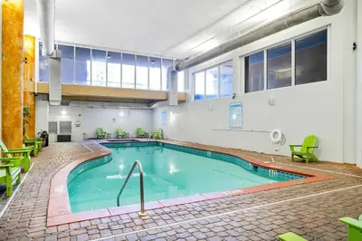 a large swimming pool in a building with green chairs at Shores of Panama 1523 in Panama City Beach