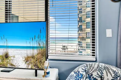 a bedroom with a large window with a view of the beach at Sunbird 412E in Panama City Beach