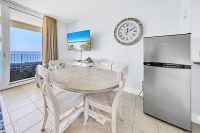 a kitchen and dining room with a table and a refrigerator at Majestic Beach Towers 1-1907 in Panama City Beach