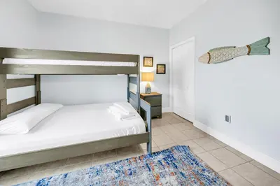 a bedroom with a bunk bed and a blue rug at Majestic Beach Towers 1-1907 in Panama City Beach