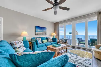 a living room with blue furniture and a view of the ocean at Laketown Wharf 1627 in Panama City Beach