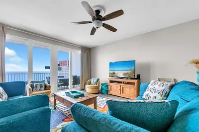 a living room with blue furniture and a flat screen tv at Laketown Wharf 1627 in Panama City Beach
