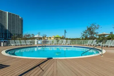 a swimming pool on a deck with chairs around it at Laketown Wharf 1627 in Panama City Beach