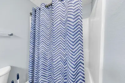 a bathroom with a blue and white chevron shower curtain at Majestic Beach Towers 1-1911 in Panama City Beach