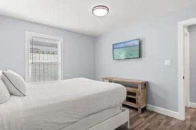 a white bedroom with a bed and a window at Beach House - Gulf Dream by Panhandle Getaways in Panama City Beach