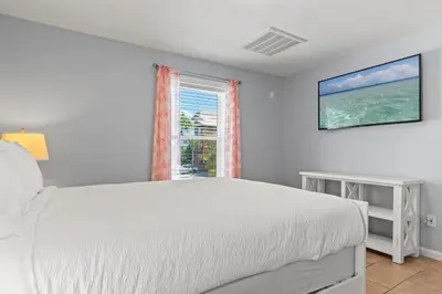 a white bedroom with a bed and a window at Beach House - Gulf Dream by Panhandle Getaways in Panama City Beach