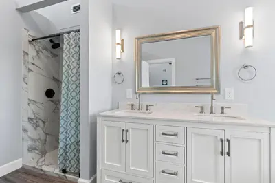 a white bathroom with two sinks and a mirror at Beach House - Gulf Dream by Panhandle Getaways in Panama City Beach