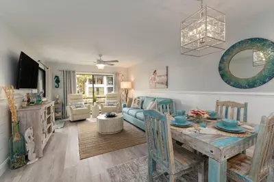 a living room with a table and a couch at Edgewater Gulf Villas 953 in Panama City Beach
