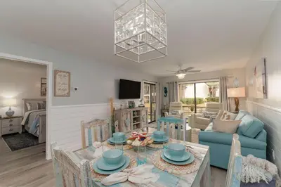 a living room with a blue couch and a table at Edgewater Gulf Villas 953 in Panama City Beach