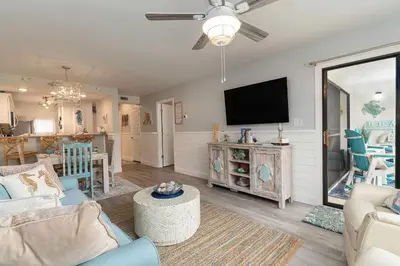 a living room with a couch and a flat screen tv at Edgewater Gulf Villas 953 in Panama City Beach