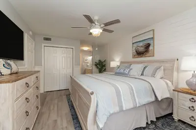 a bedroom with a bed and a flat screen tv at Edgewater Gulf Villas 953 in Panama City Beach
