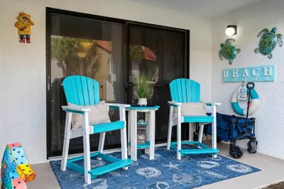 two blue chairs and a table in front of a window at Edgewater Gulf Villas 953 in Panama City Beach