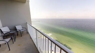 a balcony with chairs and a view of the ocean at Tidewater 3011 in Panama City Beach