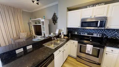 a kitchen with a sink and a stove top oven at Tidewater 3011 in Panama City Beach