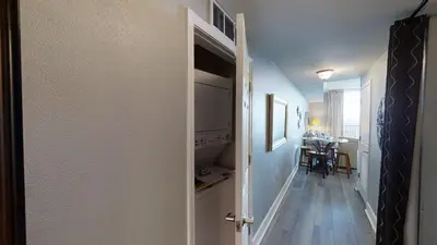 a hallway with a door open to a dining room at Tidewater 3011 in Panama City Beach