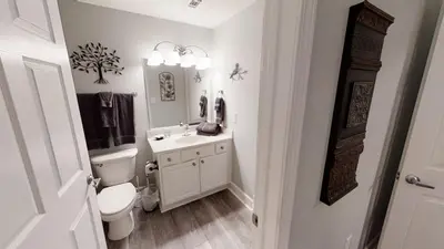 a white bathroom with a toilet and a sink at Tidewater 3011 in Panama City Beach