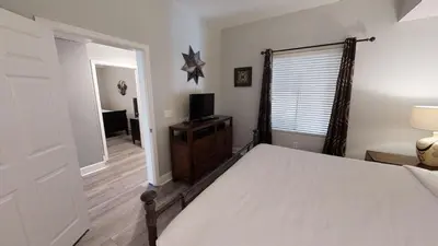 a bedroom with a bed and a television and a window at Tidewater 3011 in Panama City Beach