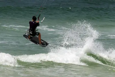 a man riding a wave on a board in the ocean at Sugar Beach 19C in Panama City Beach