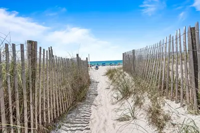 a fence on the beach next to a sandy beach at Sugar Beach 19C in Panama City Beach