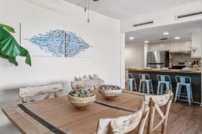 a kitchen and dining room with a wooden table and chairs at Sugar Beach 19C in Panama City Beach