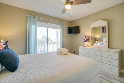a bedroom with a bed and a dresser with a mirror at Peachtree Place Condominiums by Panhandle Getaways in Panama City Beach