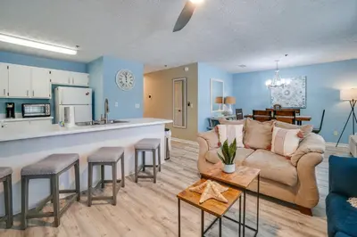 a living room with a couch and a kitchen at Peachtree Place Condominiums by Panhandle Getaways in Panama City Beach