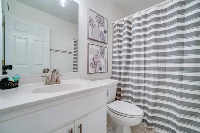 a white bathroom with a sink and a toilet at Peachtree Place Condominiums by Panhandle Getaways in Panama City Beach