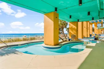 a swimming pool with the ocean in the background at Splash Beach Resort by Panhandle Getaways in Panama City Beach