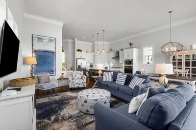 a living room with blue couches and a kitchen at 30A Pet Friendly Beach House - 33 Sunset by Panhandle Getaways in Rosemary Beach