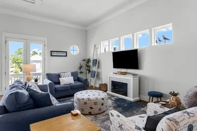 a living room with blue furniture and a tv at 30A Pet Friendly Beach House - 33 Sunset by Panhandle Getaways in Rosemary Beach