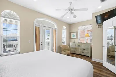 a bedroom with a bed and a dresser and windows at Summer Towne by Panhandle Getaways in Panama City Beach