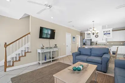 a living room with a blue couch and a tv at Summer Towne by Panhandle Getaways in Panama City Beach