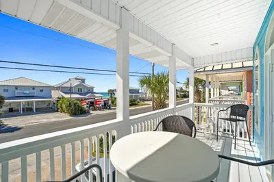 a porch with a table and chairs and a view of the street at Summer Towne by Panhandle Getaways in Panama City Beach