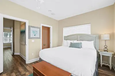a bedroom with a large white bed and a table at Summer Towne by Panhandle Getaways in Panama City Beach