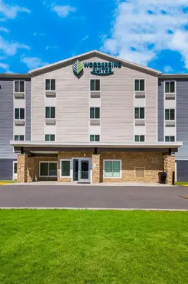 a large apartment building with a lawn in front of it at WoodSpring Suites Panama City Beach in Panama City Beach