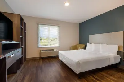 a bedroom with a white bed and a window at WoodSpring Suites Panama City Beach in Panama City Beach