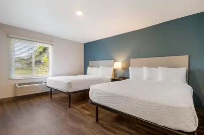 a bedroom with two beds and a window at WoodSpring Suites Panama City Beach in Panama City Beach