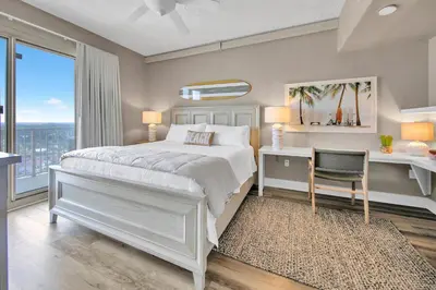 a bedroom with a bed and a desk with a chair at Gulf Crest 2107A in Panama City Beach