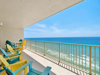 a balcony with blue and yellow chairs and the ocean at Gulf Crest 2107A in Panama City Beach