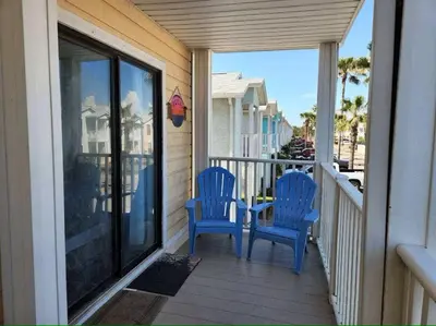 two blue chairs sitting on the porch of a house at Across the Street from beach with 2 pools in Panama City Beach
