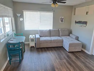 a living room with a couch and a table at Across the Street from beach with 2 pools in Panama City Beach