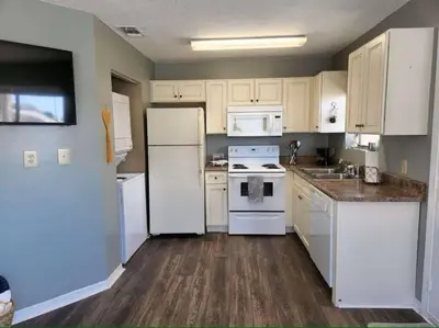 a kitchen with white appliances and white cabinets at Across the Street from beach with 2 pools in Panama City Beach