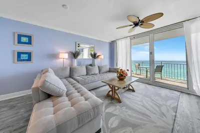 a living room with a couch and a large window at Emerald Beach 1035 in Panama City Beach