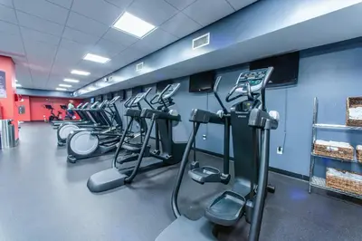 a gym with a row of treadms and machines at Emerald Beach 1035 in Panama City Beach