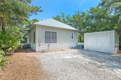 a white house with a garage and a driveway at Magnolia Cottage in Inlet Beach